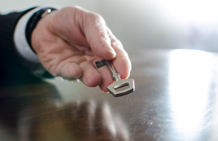 Businessman holding a key in his handの写真素材