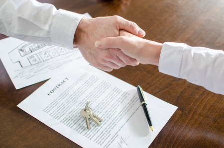 Estate agent shaking hands with his customer after contract signature