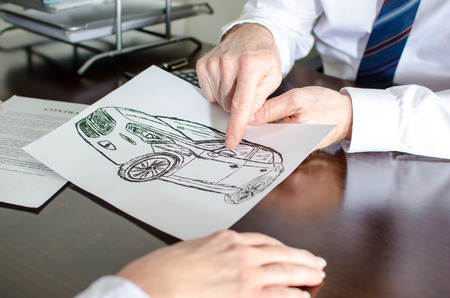 Dealer showing a detail on a car design with his finger