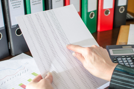 Female accountant checking financial documents at officeの写真素材