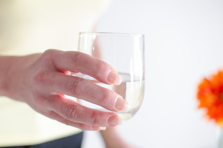 Woman holding a glass of water in her handの写真素材