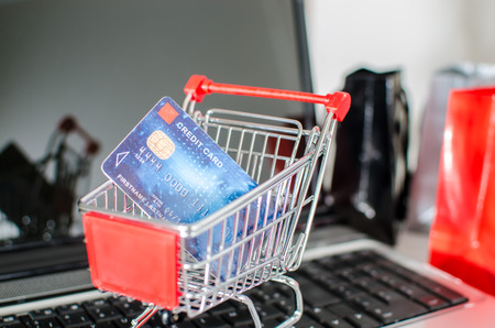 Credit card in a shopping cart on a laptopの写真素材