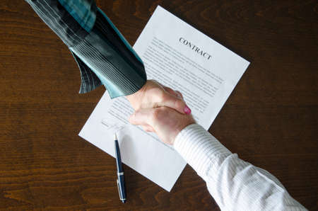 Handshake over signed contract, top viewの写真素材