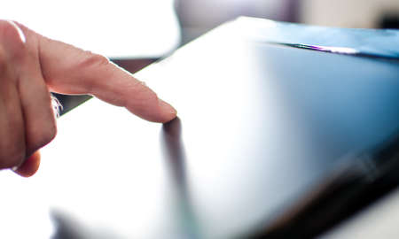 Finger touching a screen, closeup