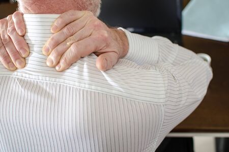 Businessman with neck pain at office