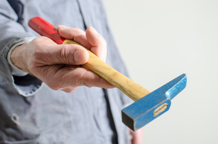 Hand holding a hammer, closeup