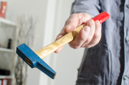 Hand holding a hammer, closeupの写真素材