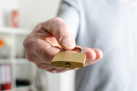Hand holding a closed padlock, closeup