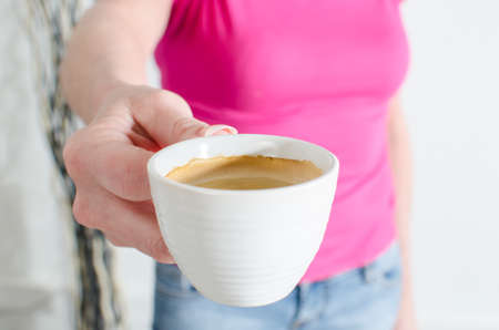 Woman showing a cup of coffee, closeupの写真素材