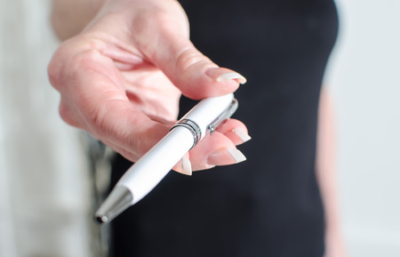 Woman showing a pen, closeup