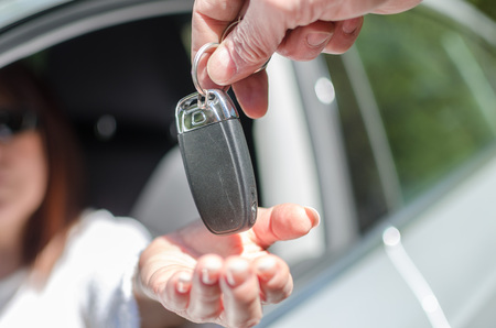 Man giving car key to a woman, closeupの写真素材