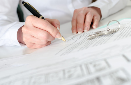 Client signing a real estate contract in real estate agencyの写真素材