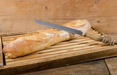 Tasty French baguette on a wooden cutting boardの写真素材