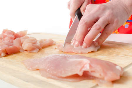 Hands of woman cutting meat on wooden boardの写真素材