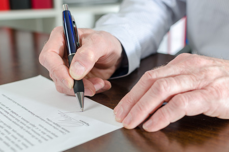 Businessman signing a document, closeupの写真素材