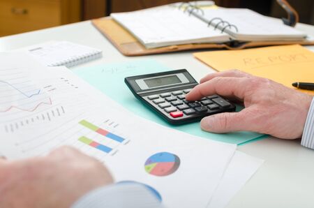 Businessman checking financial graphs, at the office