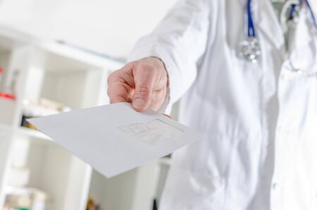 Doctor showing a letter in medical officeの写真素材