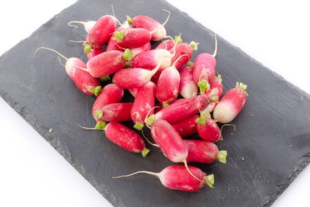 Fresh radishes on a slate plate, isolated on whiteの写真素材