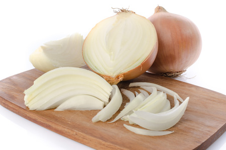 Whole and sliced onions on a cutting board, isolated on whiteの写真素材