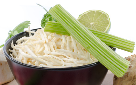 Bowl of tasty grated celery, isolated on whiteの写真素材