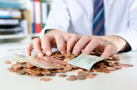 Businessman putting his hands on moneyの写真素材