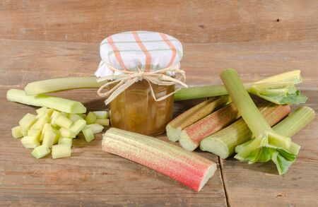 Rhubarb jam jar with fresh rhubarb on wooden backgroundの写真素材