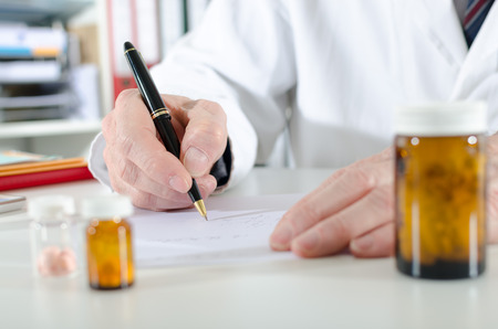 Doctor writing prescription at medical officeの写真素材