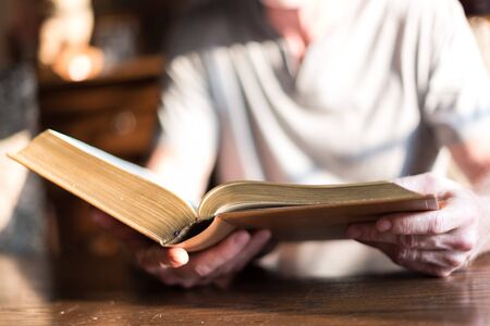 Man reading the Bible in dim light