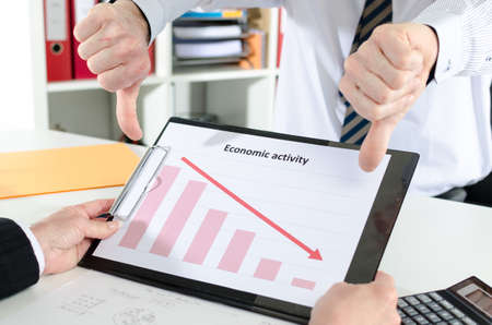 Businessman with thumbs down over graph showing crisis