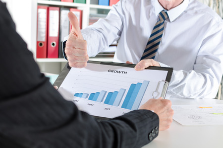 Businessman satisfied with the results showing his thumb upの写真素材