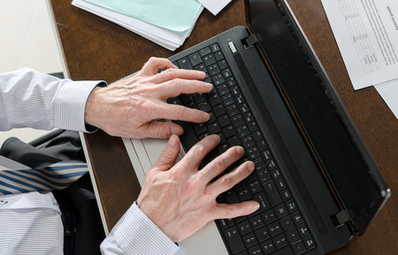 Businessman typing on a laptop at office