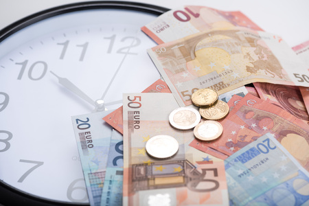 Euro banknotes on a clockの写真素材