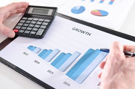 Businessman analyzing financial results with calculator