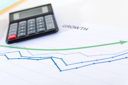 Financial graphs showing growth with calculator closeup