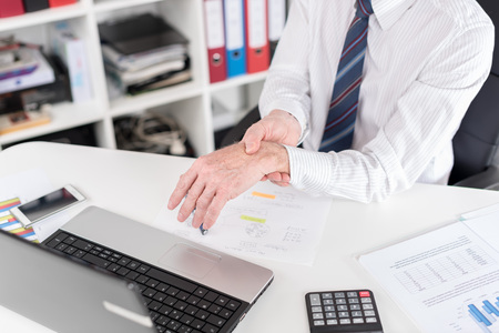 Businessman suffering from wrist pain at office