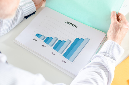 Businessman analyzing a graph showing growthの写真素材