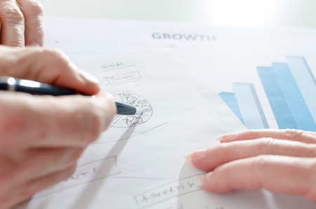 Hand pointing a pen on a diagram, closeupの写真素材