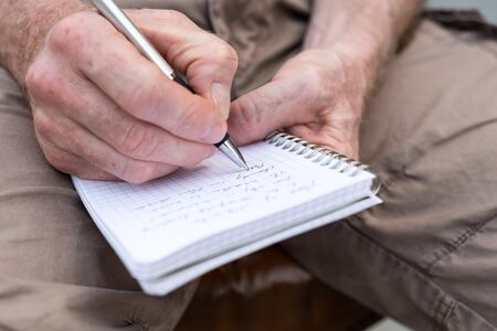 Man taking notes on a pocket book, closeupの写真素材