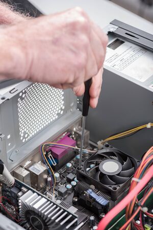 Hand repairing a computerの写真素材