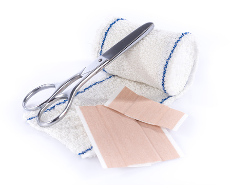Medical bandage with scissors and sticking plaster, isolated on white