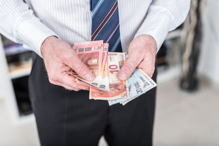 Businessman counting his money at officeの写真素材