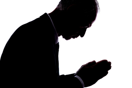 Silhouette of a man expressing prayerの写真素材