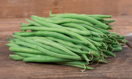 Heap of fresh green beans, on wooden background