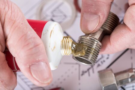 Plumber putting sealing paste on a thread, closeupの写真素材