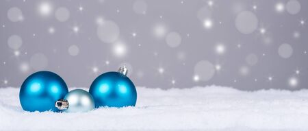 Christmas balls in snow with sparkle backgroundの写真素材