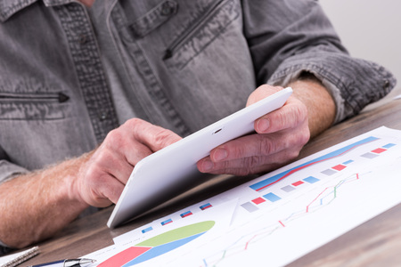 Businessperson analyzing financial charts with tablet computer