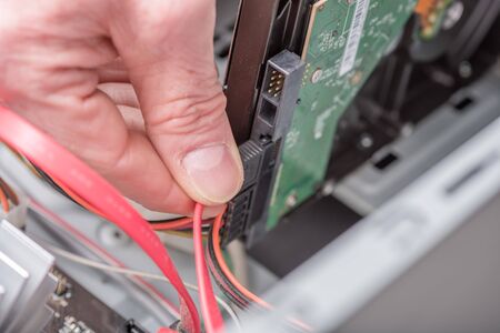Computer technician connecting a sata cable