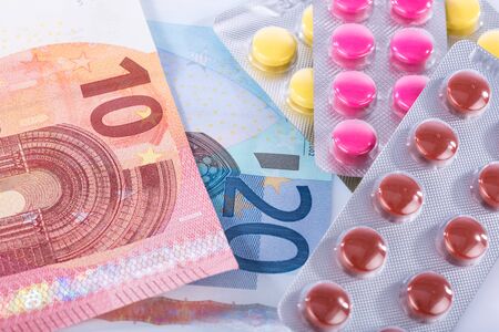 Concept of health care costs with pills and banknotesの写真素材