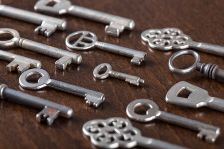 Aligned old keys on wooden background