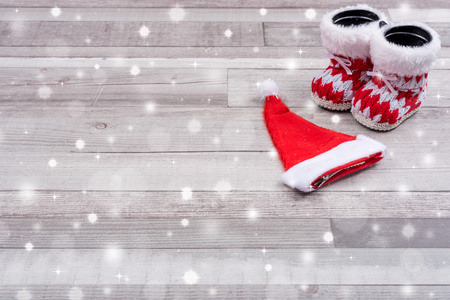 Santa boots and hat on wooden background